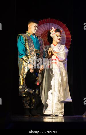 Couple japonais en costumes traditionnels debout sur un fond sombre. Banque D'Images