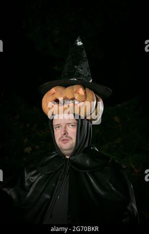 Portrait d'un homme avec une citrouille sur sa tête. Le gars dans le costume Dracula. Banque D'Images