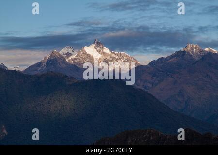 Le soleil s'élève au-dessus de la montagne enneigée près des ruines de Machu Picchu, au Pérou Banque D'Images