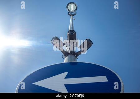 Trois caméras de surveillance fixées sur le poteau de signalisation routière avec un projecteur LED sur le dessus. Ciel bleu avec rayons de soleil comme arrière-plan Banque D'Images