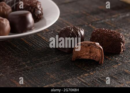 Assortiment de truffes au chocolat sur une table en bois rustique dans un environnement sombre Banque D'Images