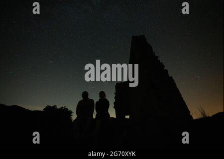 Vorderweidenthal, Allemagne. 10 juillet 2021. Deux personnes s'assoient devant le ciel étoilé au château de Lindelbrunn. Credit: Sebastian Gollnow/dpa/Alay Live News Banque D'Images