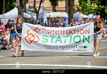 Prescott, Arizona, États-Unis - 3 juillet 2021 : deux filles portant une station de vaccination signent Spectrum Health pendant leur marche dans le défilé du 4 juillet Banque D'Images