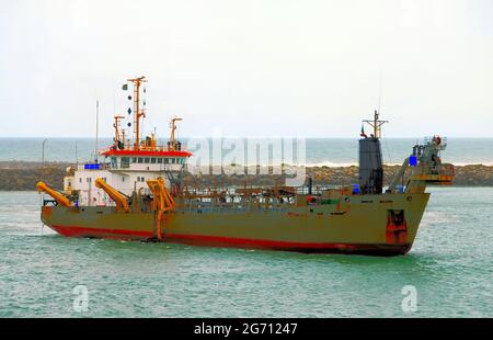 Un navire de mer entrant dans le port de Cotonou, Bénin, Afrique de l'Ouest, sur un tropical, ensoleillé, jour. Banque D'Images