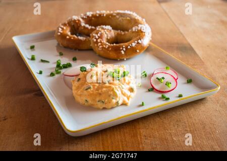 Obatzda, une tartinade bavaroise appelée aussi Obatzter ou Obazda avec un Pretzel appelé Brezel ou Laugenbrezel Banque D'Images