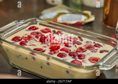 Pâte prête à l'emploi avec cerises dans le moule à tarte aux cerises, clafoutis. Recette étape par étape. Banque D'Images