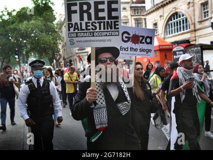 Londres, Royaume-Uni. 09e juillet 2021. Un membre du groupe orthodoxe juif antisioniste The Neturei Karta a une pancarte portant la mention « Free Palestine tandis que la police surveille la procession.des étudiants et d'autres manifestants font une visite dans les universités de Londres pour demander un boycott à toutes les institutions académiques et culturelles israéliennes solidaires de la lutte Mettre fin à l'occupation, à la colonisation et au système d'apartheid d'Israël. (Photo par Martin Pope/ SOPA Images/Sipa USA) crédit: SIPA USA/Alay Live News Banque D'Images