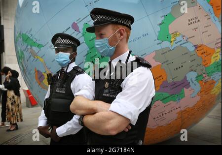 Londres, Royaume-Uni. 09e juillet 2021. Les policiers se tiennent à côté de la sculpture de Mark Wallinger « le monde s'est renversé » pendant la manifestation.des étudiants et d'autres manifestants se rendent dans les universités de Londres pour demander le boycott de toutes les institutions académiques et culturelles israéliennes en solidarité avec la lutte pour mettre fin à l'occupation israélienne, Colonisation et système d'apartheid en Israël. (Photo par Martin Pope/ SOPA Images/Sipa USA) crédit: SIPA USA/Alay Live News Banque D'Images