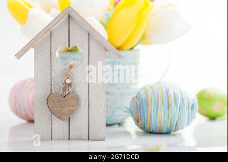 Décoration de Pâques avec œufs, maison d'oiseaux et fleurs de tulipe Banque D'Images