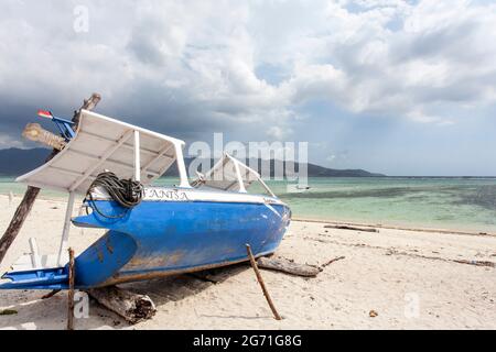 Bateau de pêche bleu et blanc sur la plage de Gili Air, Indonésie, Asie du Sud-est Banque D'Images