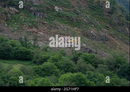 Véhicule d'excavation jaune travaillant sur le côté d'une montagne dans les balises de Brecon Banque D'Images