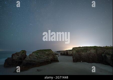 Ribadeo, Espagne. 10 juillet 2021. Les étoiles brillent pendant une nuit d'été sur les formations rocheuses de 'Playa de las Catedrales' (plage des cathédrales). La plage est célèbre pour ses arches naturelles et ses grottes et a été déclarée Monument naturel. Il est situé sur la côte nord-ouest de l'Espagne, en Galice, près de la ville de Ribadeo. Credit: Marcos del Mazo/Alay Live News Banque D'Images