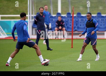 Gareth Southgate, directeur de l'Angleterre, observe Jude Bellingham et Raheem Sterling lors d'une séance d'entraînement au parc St George, Burton Upon Trent. Date de la photo: Samedi 10 juillet 2021. Banque D'Images