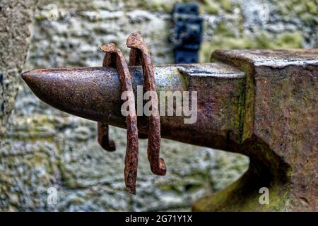 Belle exposition d'époque avec enclume et fers à cheval âgés dans le village de Ford et l'etal dans le comté de Northumberland - Angleterre - Royaume-Uni Banque D'Images