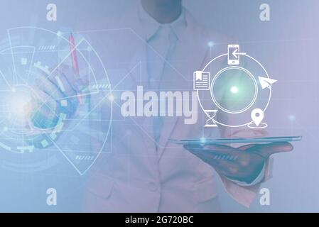 Femme dans une tablette de maintien uniforme montrant une interface virtuelle futuriste. Lady en costume utilisant un appareil Pencil Mobile interagir avec holographique Banque D'Images