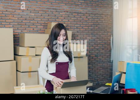 Petite entreprise démarrage entrepreneur PME ou femme freelance travaillant avec des boîtes à la maison ou au bureau. Manutention des colis de livraison. Pack de marketing en ligne Banque D'Images