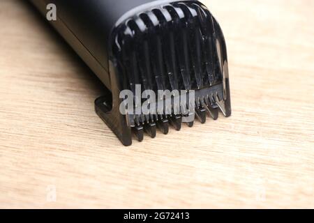 Tondeuse barbe avec gros plan de la partie clip sur fond en bois Banque D'Images