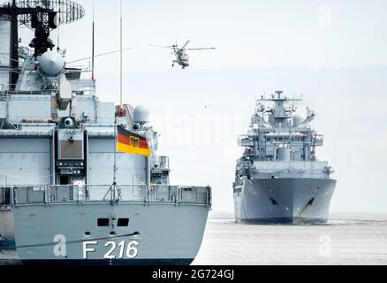 Wilhelmshaven, Allemagne. 10 juillet 2021. Le navire de ravitaillement de la force opérationnelle 'Berlin', accompagné d'un hélicoptère de la marine, entre dans le port à la base navale. Le navire est retourné à Wilhelmshaven après une mission de l'UE d'une durée d'environ quatre mois, dont le but était d'arrêter le trafic d'armes à travers la Méditerranée vers la Libye. Credit: Hauke-Christian Dittrich/dpa/Alay Live News Banque D'Images