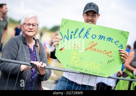 Wilhelmshaven, Allemagne. 10 juillet 2021. Les parents accueillent les membres de leur famille alors que le navire de ravitaillement de la force opérationnelle « Berlin » entre dans le port à la base navale. Le navire est retourné à Wilhelmshaven après une mission de l'UE d'une durée d'environ quatre mois, dont le but était d'arrêter le trafic d'armes à travers la Méditerranée vers la Libye. Credit: Hauke-Christian Dittrich/dpa/Alay Live News Banque D'Images