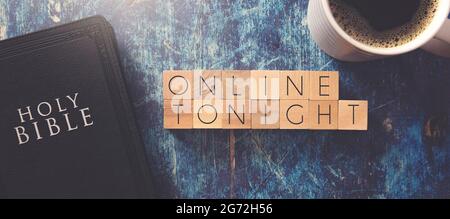 En ligne ce soir écrit en bloc lettres sur une table en bois bleu avec une Bible noire Banque D'Images