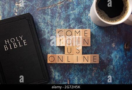 Venez nous rejoindre écrit en lettres bloc sur une table en bois bleu avec une Bible noire Banque D'Images
