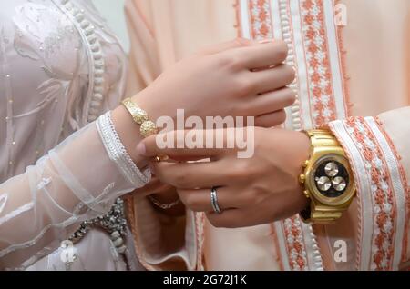 Mariage marocain. Le marié met un bracelet sur la main de la mariée Banque D'Images