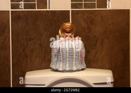 Poupée de toilette, une poupée Barbie avec robe crochet sur un rouleau de toliet Banque D'Images