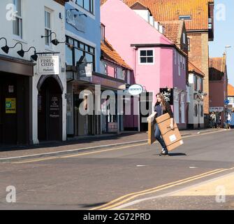 Femme transportant des boîtes en carton sur une route Banque D'Images