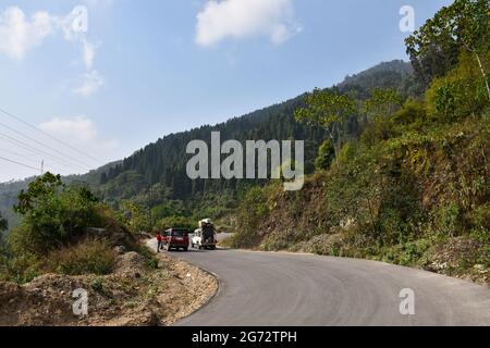 Véhicule sur route asphaltée sinueuse et forêt de pins. Banque D'Images