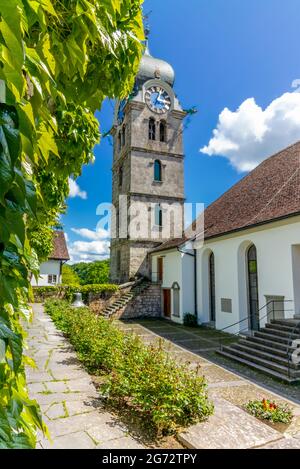 Le mur et le jardin de l'église de la ville médiévale d'Eglisau en Suisse dans un jour de printemps ensoleillé et chaud avec le clocher en arrière-plan Banque D'Images