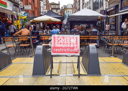 Londres, Royaume-Uni. 10 juillet 2021. COVID-19 panneau restrictions temporaires vu dans Old Compton Street, Soho. Plusieurs rues du centre de Londres ont été bloquées pour cause de circulation à certaines heures de la journée et le week-end pour permettre aux bars et aux restaurants de s'asseoir en plein air pendant la pandémie du coronavirus. (Photo de Vuk Valcic/SOPA Images/Sipa USA) crédit: SIPA USA/Alay Live News Banque D'Images