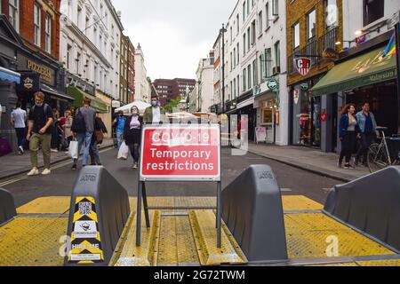 Londres, Royaume-Uni. 10 juillet 2021. COVID-19 panneau restrictions temporaires vu dans Old Compton Street, Soho. Plusieurs rues du centre de Londres ont été bloquées pour cause de circulation à certaines heures de la journée et le week-end pour permettre aux bars et aux restaurants de s'asseoir en plein air pendant la pandémie du coronavirus. (Photo de Vuk Valcic/SOPA Images/Sipa USA) crédit: SIPA USA/Alay Live News Banque D'Images