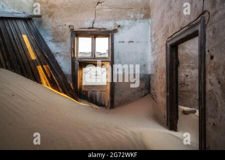 Bâtiment abandonné en train d'être repris par l'empiétement du sable, ville fantôme de Kolmanskop, désert du Namib, Namibie. Banque D'Images