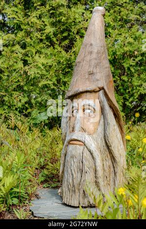 St Andrews, N.-B., Canada - le 5 mai 2017 : une grande tête de sorcier en bois sculpté. Assistant a une barbe et a pointé. La peinture est décolorée. Banque D'Images