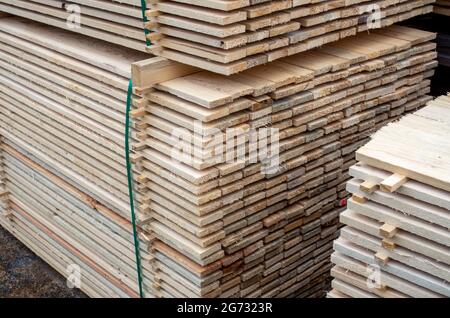 grandes piles de planches en bois au dépôt de matériaux de construction. Banque D'Images