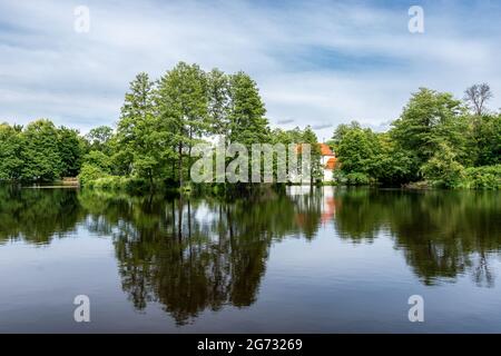 Belle vue sur l'étang à Zwierzyniec, Roztocze, Pologne. Parc et célèbre église Saint-Jean de Nepomuk sur l'île en arrière-plan. Banque D'Images