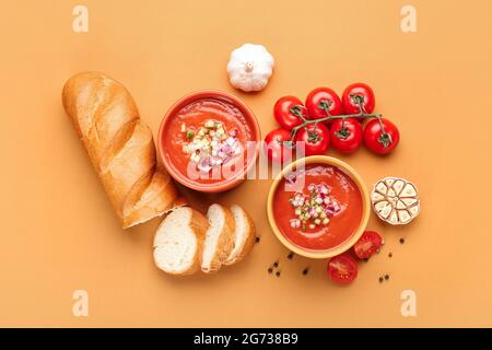 Composition avec gazpacho savoureux dans des bols et du pain sur fond de couleur Banque D'Images