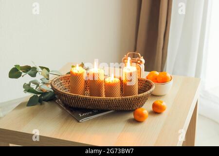 Plateau avec bougies allumées et mandarines fraîches sur la table dans la chambre Banque D'Images