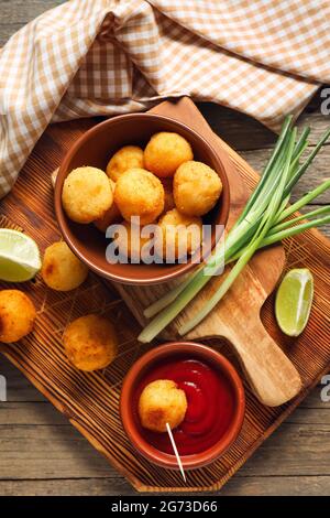 Composition avec boules de pommes de terre frites sur fond de bois Banque D'Images