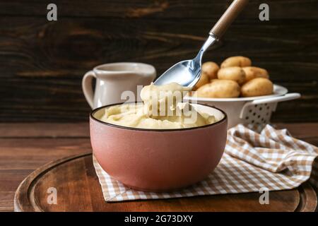 Bol avec une purée de pommes de terre savoureuse sur fond de bois Banque D'Images