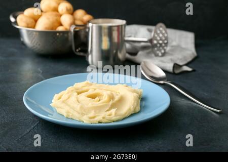 Assiette avec une purée de pommes de terre savoureuse sur fond sombre Banque D'Images