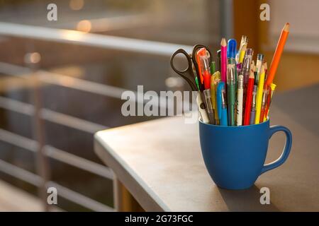tasse bleue avec différents stylos Banque D'Images