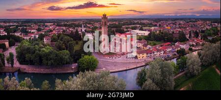 Vue aérienne de l'église Casale sul Sile et du port sur la rivière Sile au coucher du soleil. Sur la gauche, la tour médiévale de Carraresi. Banque D'Images