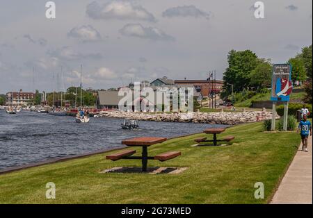 South Haven, MI, États-Unis - 7 juin 2008 : tables et bancs bruns sur pelouse verte avec vue sur le bâtiment de la marina et les bateaux sur la rivière Black près de l'entrée-sortie à L Banque D'Images