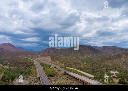 Aventure voyage route du désert vue panoramique de l'autoroute asphaltée à travers les montagnes arides du désert Arizona Banque D'Images