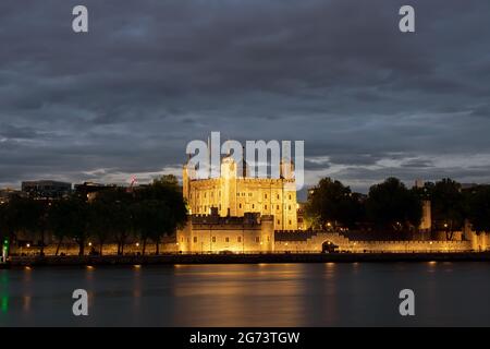 La Tour de Londres s'illumina la nuit, vue depuis les rives sud de la Tamise à Londres, en Angleterre. Les lumières se réfléchissent de l'eau. Banque D'Images