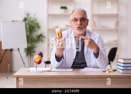 Ancien professeur de dentiste assis dans la salle de classe Banque D'Images