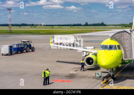 Avant de S7 compagnies aériennes avion, personnel aéroportuaire et véhicules de transport sur le tarmac de taxi de l'aéroport international de Tolmachevo, Novosibirsk, Russie Banque D'Images