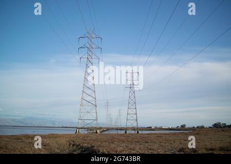 Tours de transmission en deux lignes avec câbles d'alimentation au-dessus du marais dans la baie de San Francisco Banque D'Images