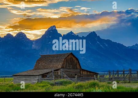 Une vue sur la grange John et Bartha Molton avec la toile de fond spectaculaire du coucher de soleil sur la chaîne de Teton dans le parc national de Grand Teton, WY, États-Unis. Banque D'Images